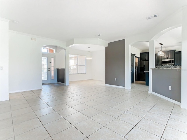 unfurnished living room featuring crown molding and light tile patterned floors