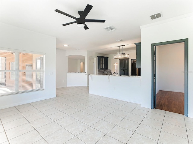 3623 Weatherfield Dr, Kissimmee, FL 34746 - unfurnished living room featuring light tile patterned floors, arched walkways, ceiling fan, and visible vents