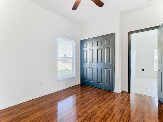 unfurnished bedroom with wood-type flooring, a closet, and ceiling fan