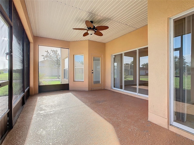 unfurnished sunroom with ceiling fan and plenty of natural light