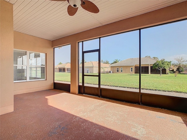 unfurnished sunroom with ceiling fan