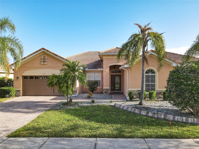 mediterranean / spanish home with a front lawn and a garage