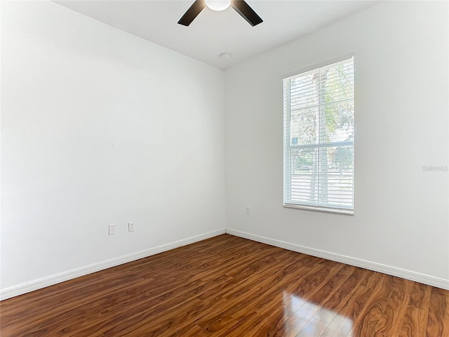 empty room with dark wood-type flooring and ceiling fan