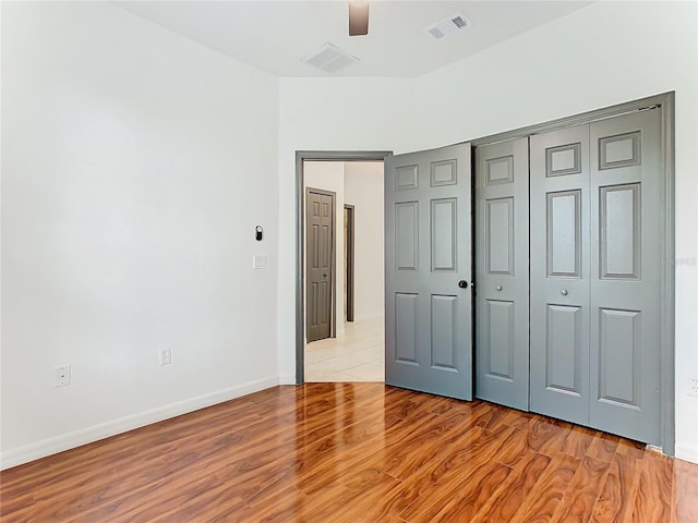 unfurnished bedroom with a closet, light wood-type flooring, and ceiling fan