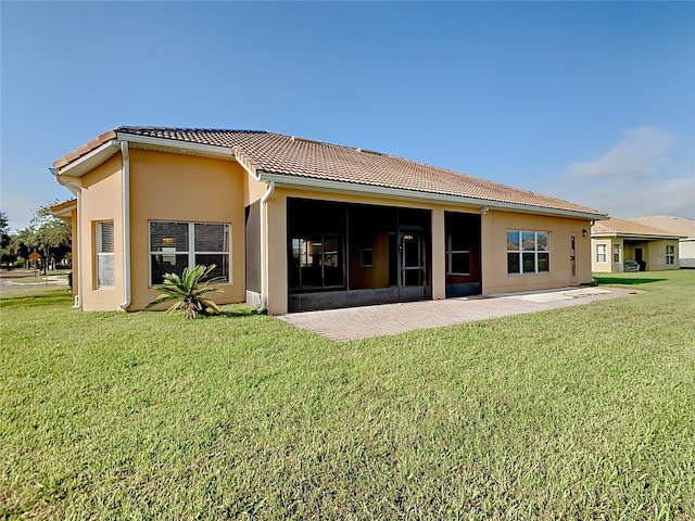 3623 Weatherfield Dr, Kissimmee, FL 34746 - rear view of property featuring a sunroom, stucco siding, a yard, and a tile roof