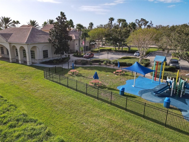 view of home's community featuring a playground and a lawn