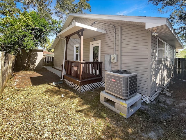 view of property exterior with a deck and central AC unit