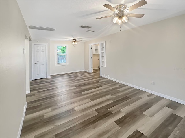 spare room with dark hardwood / wood-style floors and ceiling fan