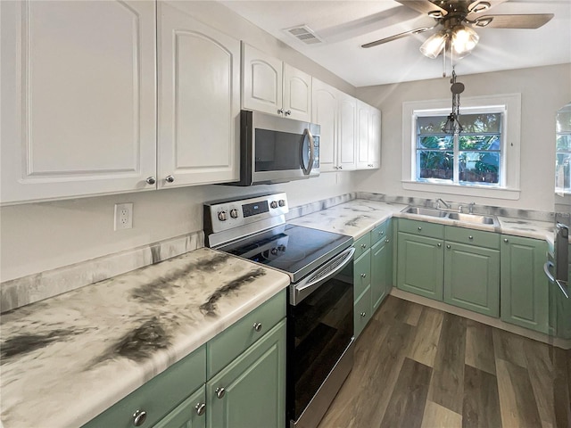 kitchen featuring dark wood-type flooring, green cabinets, sink, white cabinets, and appliances with stainless steel finishes