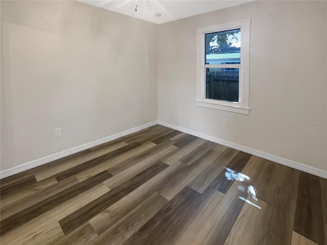 unfurnished room with dark wood-type flooring