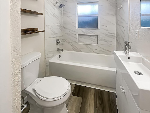 full bathroom with vanity, hardwood / wood-style floors, tiled shower / bath combo, and toilet