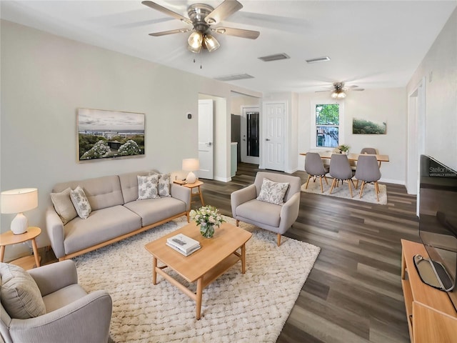 living room featuring dark wood-type flooring and ceiling fan