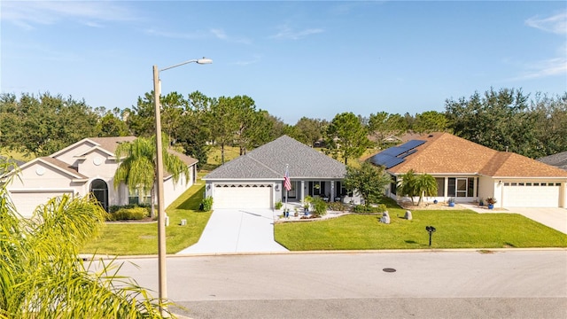 view of front facade featuring a front lawn, a garage, and solar panels