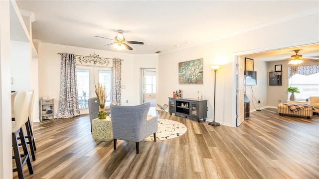 living room featuring crown molding, hardwood / wood-style floors, and ceiling fan