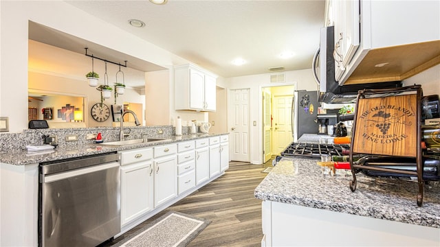 kitchen featuring sink, dark wood-type flooring, stainless steel appliances, light stone counters, and white cabinets