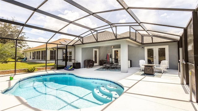 view of swimming pool featuring a lanai, ceiling fan, a patio area, and french doors