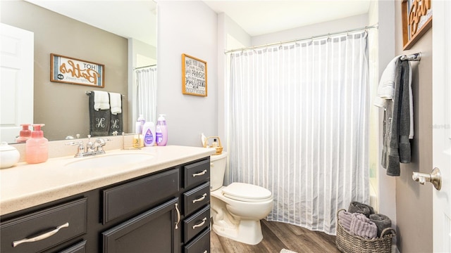 full bathroom with wood-type flooring, vanity, shower / tub combo, and toilet