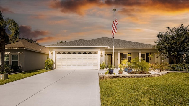 view of front of property featuring a yard and a garage