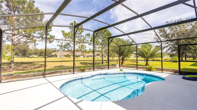 view of pool with glass enclosure, a patio area, and a yard