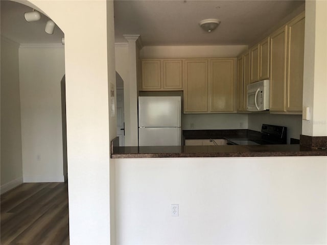 kitchen featuring dark wood-type flooring, kitchen peninsula, crown molding, and white appliances