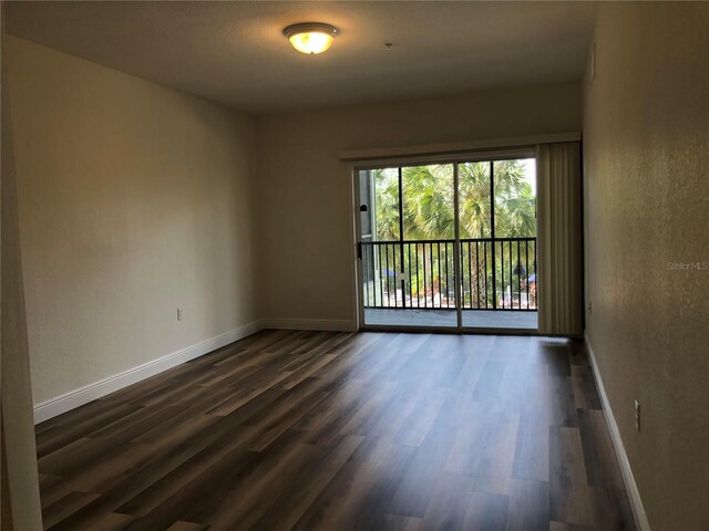 empty room with dark hardwood / wood-style flooring