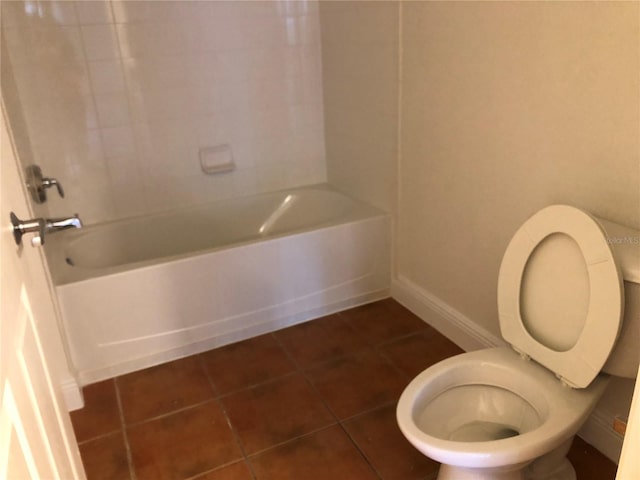 bathroom featuring tiled shower / bath, tile patterned floors, and toilet