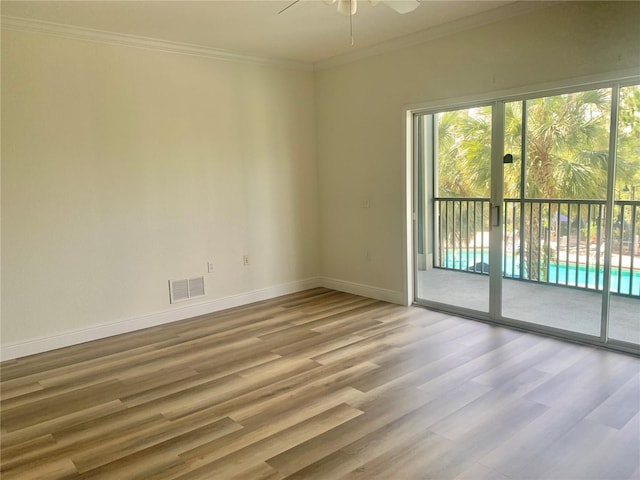 empty room featuring ornamental molding, light hardwood / wood-style flooring, and ceiling fan