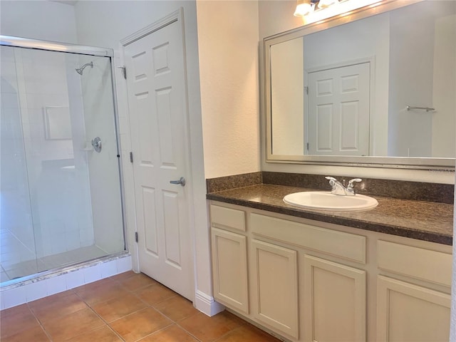 bathroom featuring a shower with door, tile patterned floors, and vanity