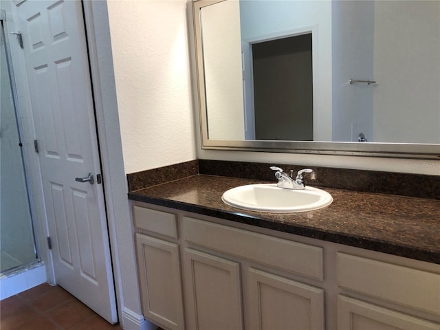 bathroom featuring vanity, a shower, and tile patterned flooring