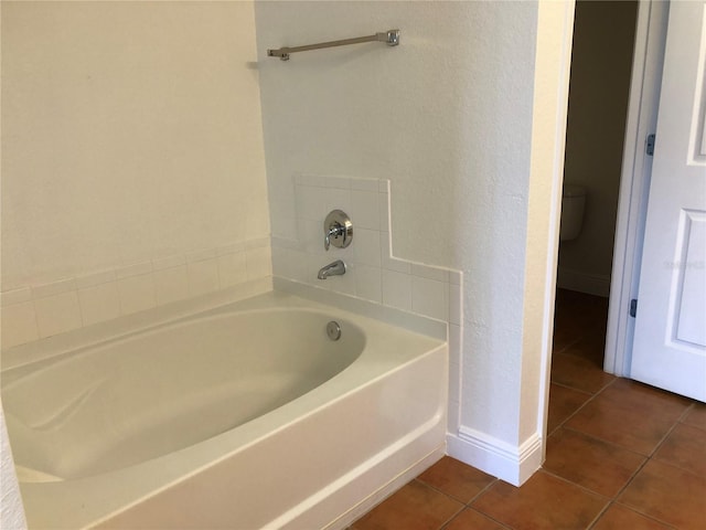 bathroom with tile patterned floors, toilet, and a bathing tub