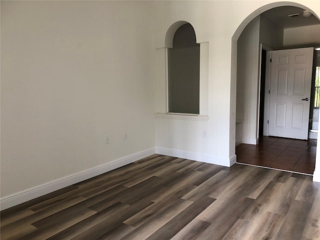 spare room with dark wood-type flooring