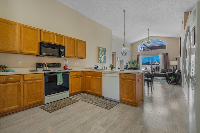 kitchen with light hardwood / wood-style flooring, kitchen peninsula, decorative light fixtures, white appliances, and ceiling fan