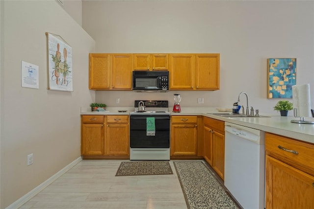 kitchen featuring white dishwasher, sink, electric range, and light hardwood / wood-style flooring