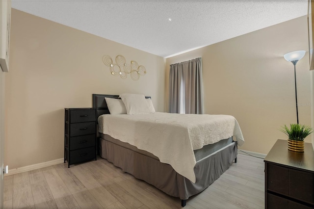 bedroom featuring a textured ceiling and light hardwood / wood-style floors