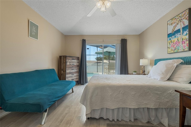 bedroom with a textured ceiling, access to exterior, light wood-type flooring, and ceiling fan