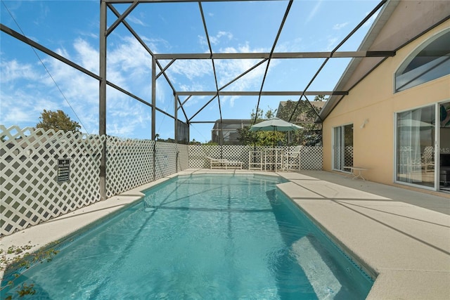 view of swimming pool featuring a patio and a lanai