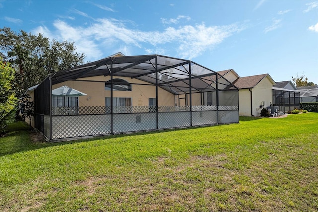 back of property featuring a lawn and glass enclosure