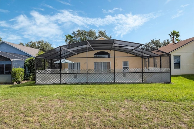 rear view of house with a yard and glass enclosure