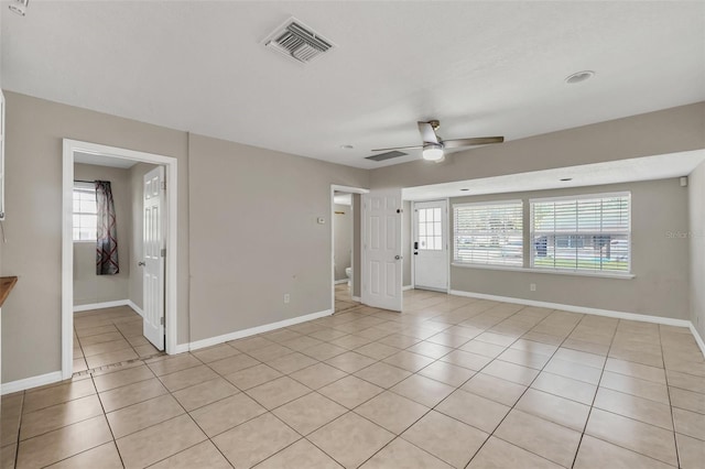 tiled spare room with ceiling fan