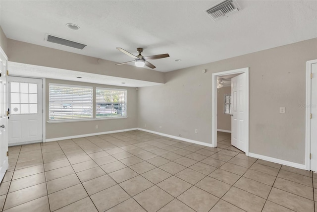 empty room featuring ceiling fan and light tile patterned floors