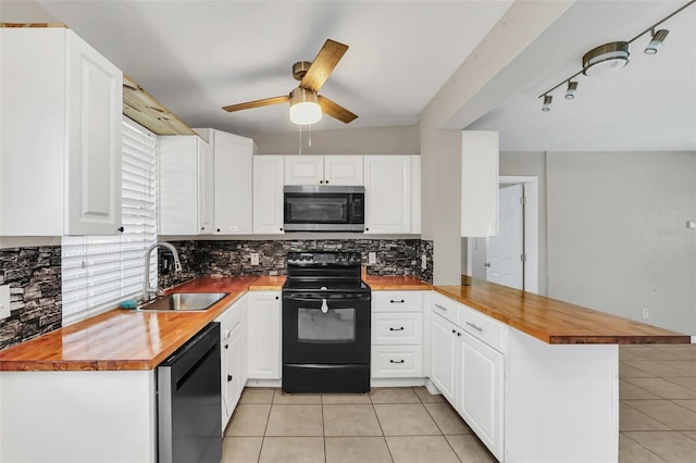 kitchen with kitchen peninsula, white cabinetry, butcher block counters, black appliances, and sink