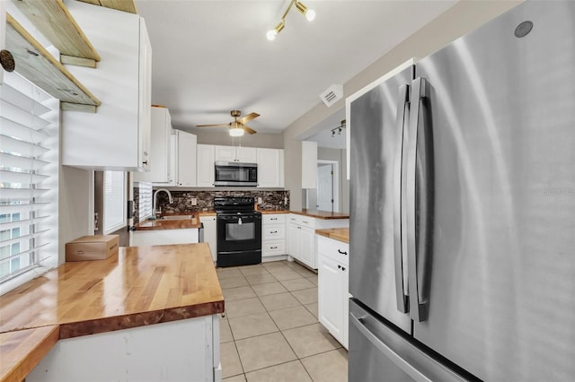 kitchen featuring appliances with stainless steel finishes, wood counters, white cabinetry, and light tile patterned floors