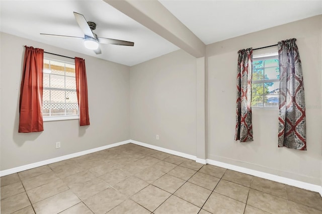 tiled empty room featuring ceiling fan and beam ceiling