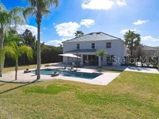 view of swimming pool featuring a lawn and a patio area