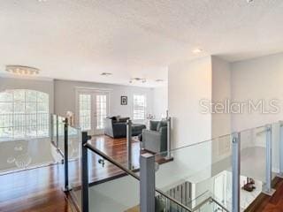 dining space with dark wood-type flooring, a textured ceiling, and french doors