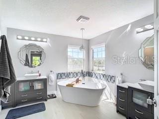 bathroom featuring vanity and a tub to relax in