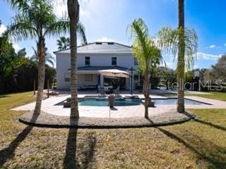 back of house with a patio and a yard