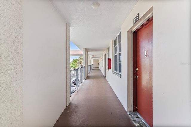 hall with a textured ceiling and concrete floors