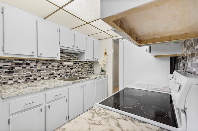 kitchen featuring dishwasher, a drop ceiling, backsplash, range, and white cabinetry