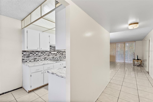 corridor featuring light tile patterned flooring and sink